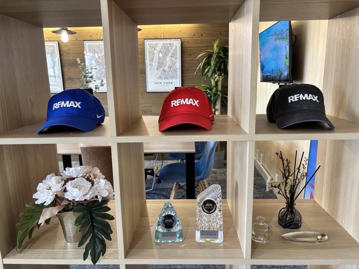 RE/MAX のキャップと表彰トロフィーを飾った棚
